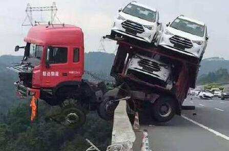 惊险！拖挂式货车在高速冲出护栏悬挂半空