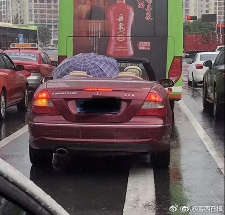男子为博关注雨天撑伞开敞篷车跑车被罚款记分