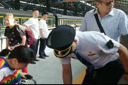 抱着病患旅客下车的列车长