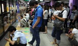 地铁“低头族”不分场合看手机 自己危险还影响别人