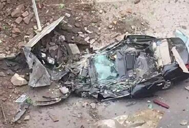 巨石从天而降 路边轿车被砸成铁饼