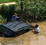 小车不慎开入水塘 交警顶高温紧急施救